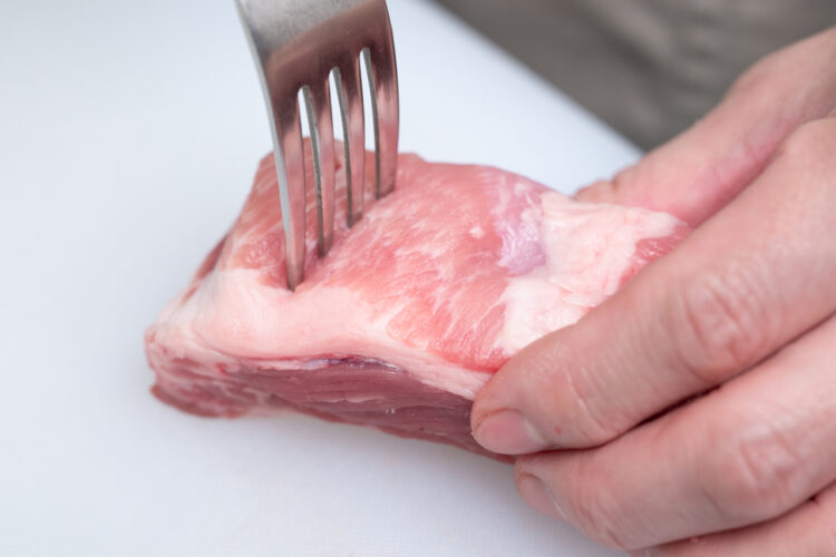 肉の表面にフォークを刺して穴を開ける